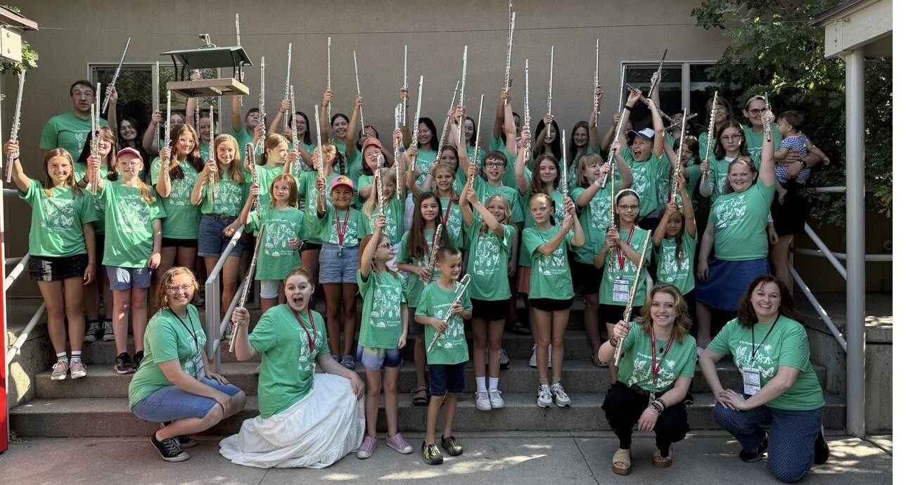 Members of the Utah Flute Association raising their flutes together in a group photo
