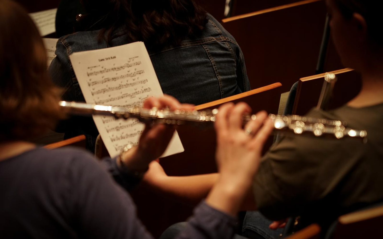 Flutists reading from shared sheet music