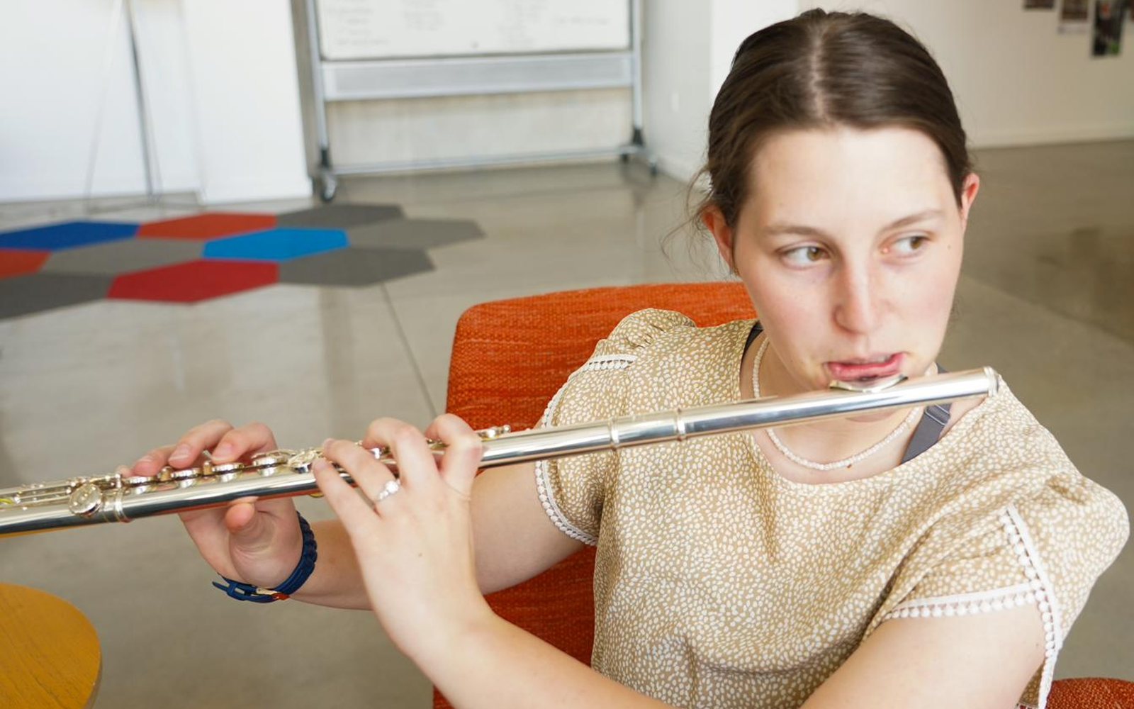 Student practicing flute in a classroom