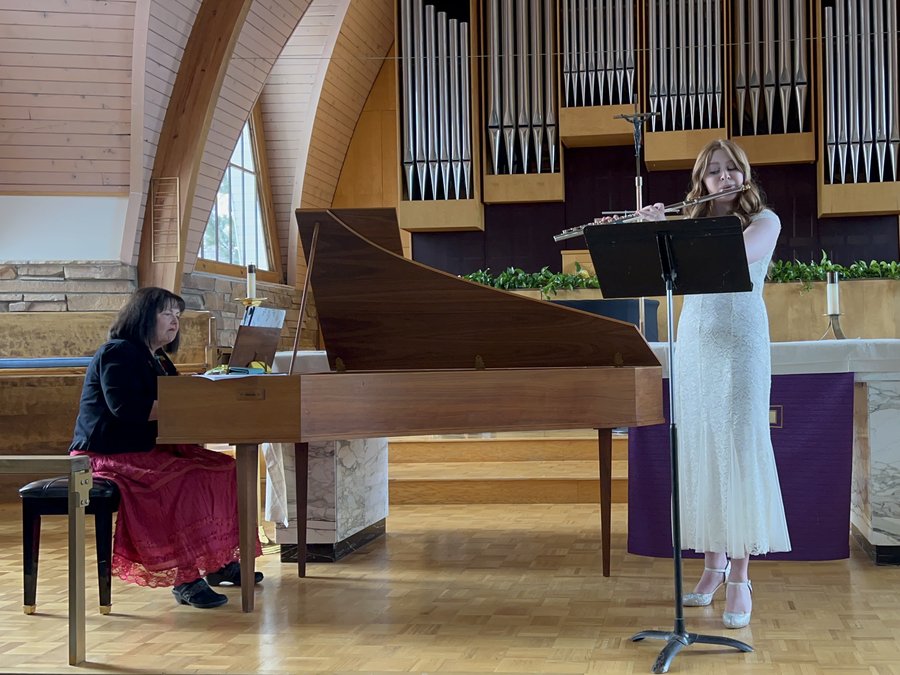 A flutist performing with harpsichord accompaniment at a UFA event